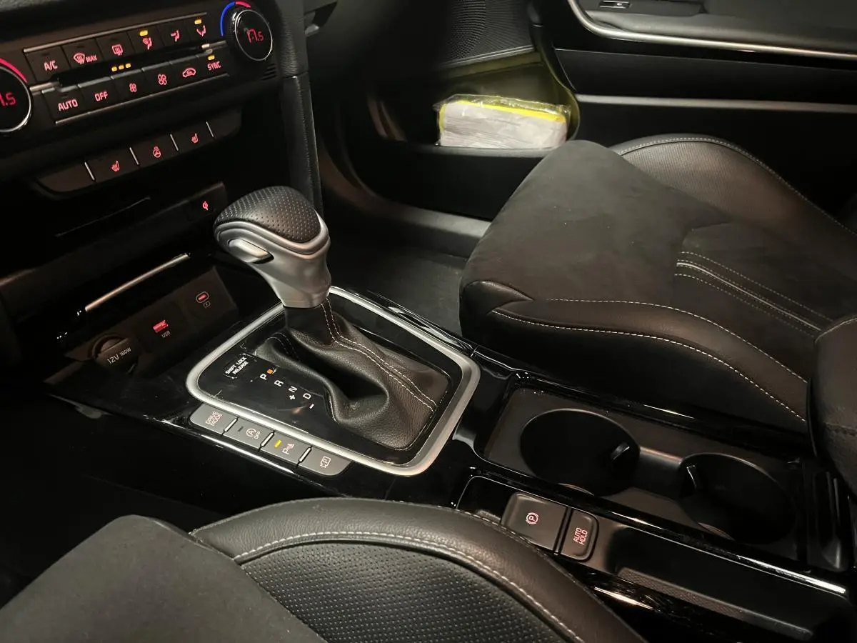 Gros plan sur la console centrale et levier de vitesses automatique de la Kia Ceed GT Line Premium 2023 en intérieur noir.