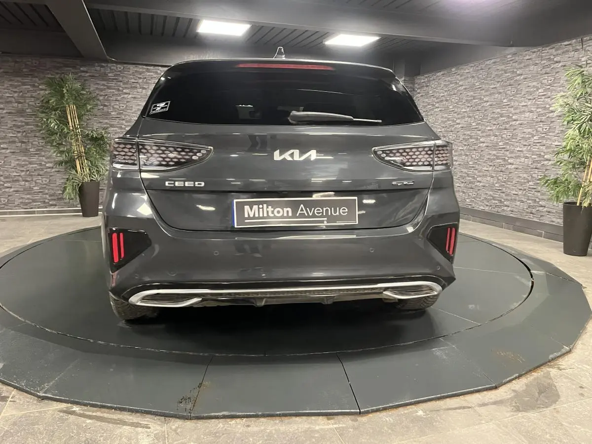 Vue arrière d'une Kia Ceed gris métallisé GT Line avec feux arrière en nid d'abeille et double sortie d'échappement intégrée.
