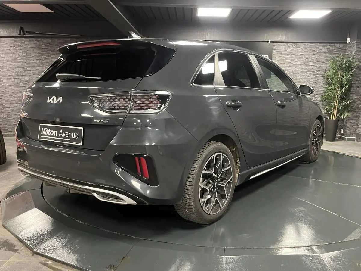 Vue 3/4 arrière droite d'une Kia Ceed gris métallisé GT Line Premium avec jantes alliage et becquet arrière.