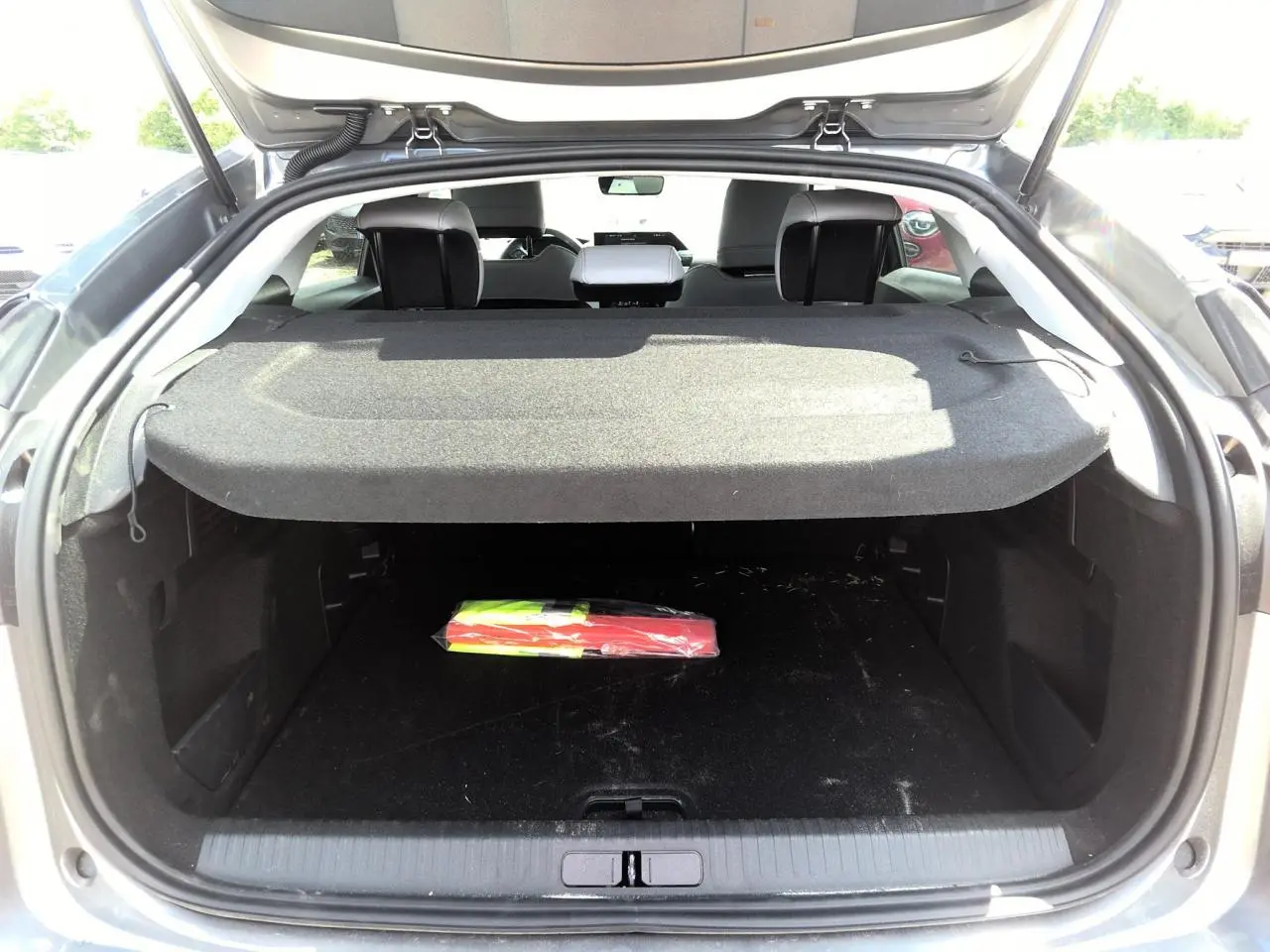 Coffre ouvert d'une Citroën C4 gris Mercury, vue arrière montrant l'espace de chargement et la tablette cache-bagages.