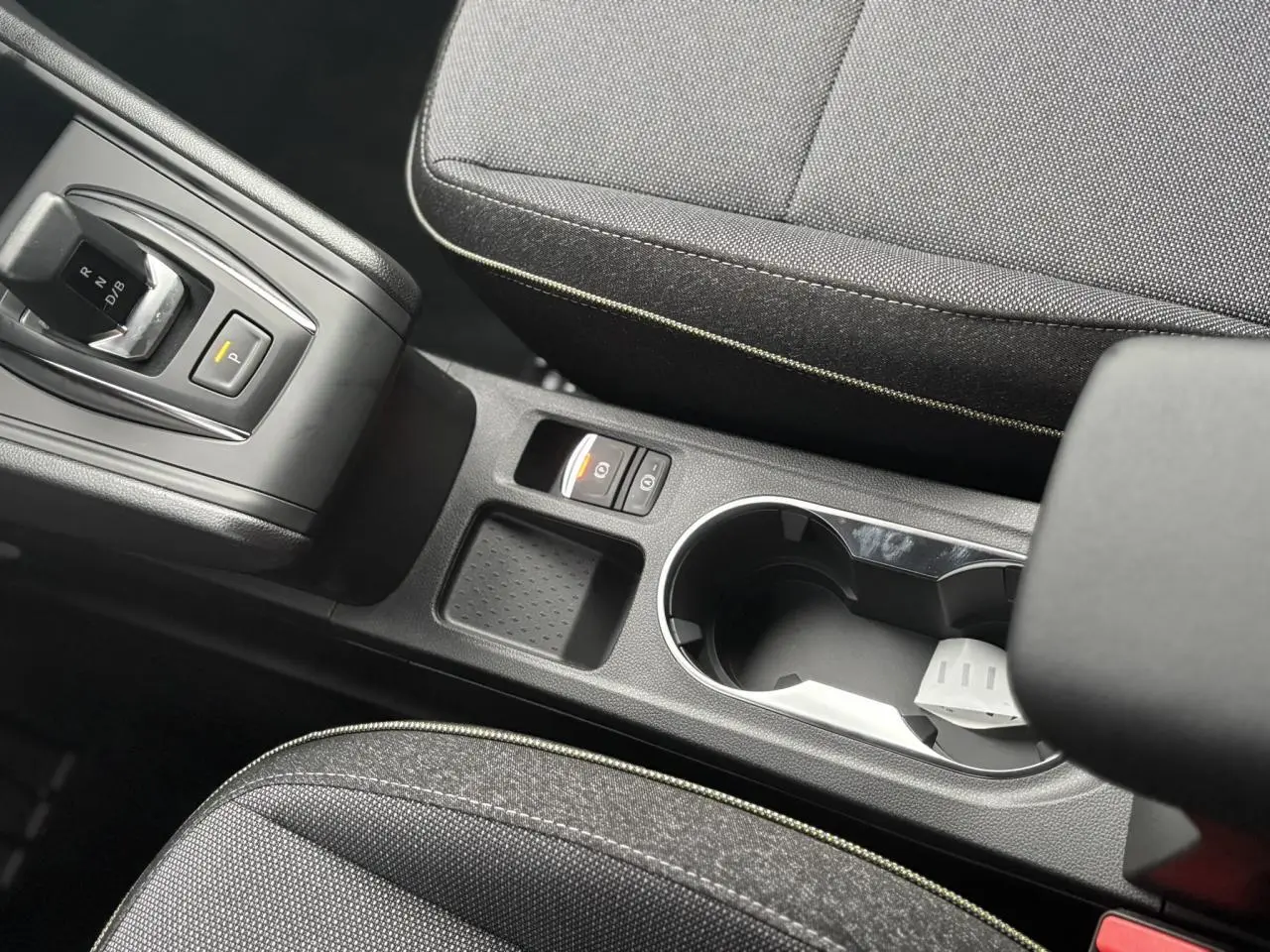 Vue rapprochée de la console centrale noire avec levier de vitesses et porte-gobelets du Renault Captur gris Cassiopée 2025.