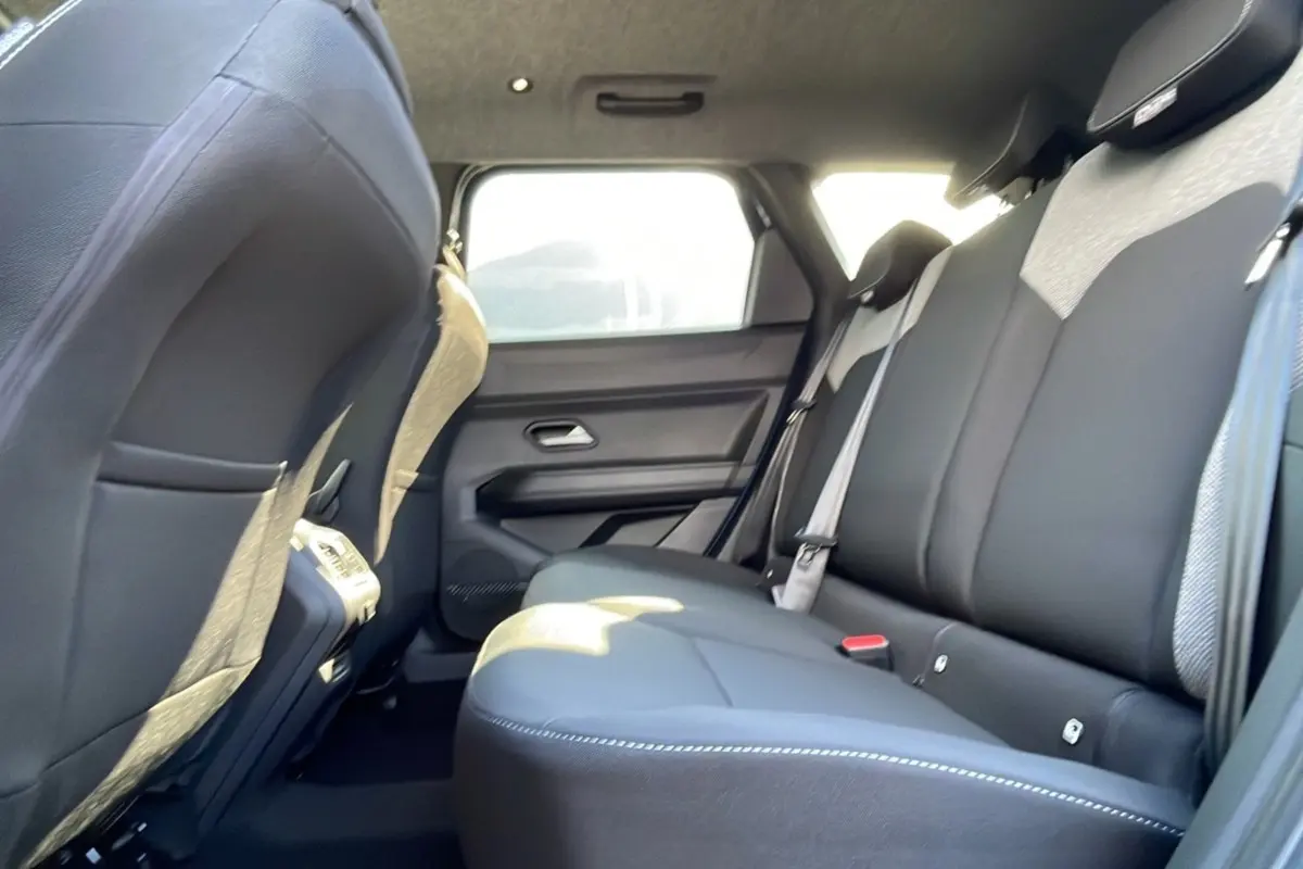 Vue intérieure de la banquette arrière noire du Dacia Bigster Hybrid 155 Journey City, côté droit, avec ceinture grise.