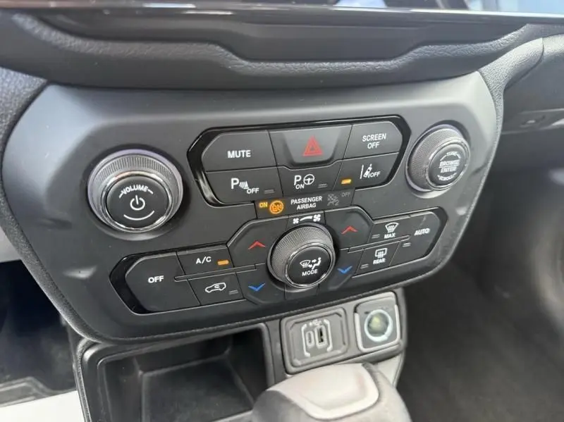 Gros plan sur la console centrale noire du Jeep Renegade 2024, montrant les commandes climatisation et audio.
