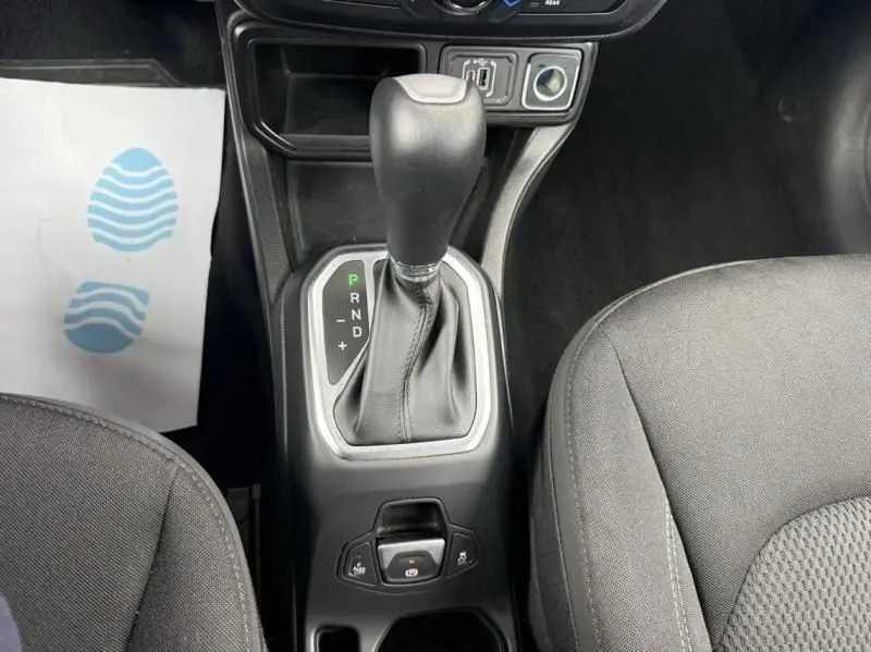 Vue rapprochée de la console centrale du Jeep Renegade 2024, levier de boîte auto entouré de sièges gris foncé.