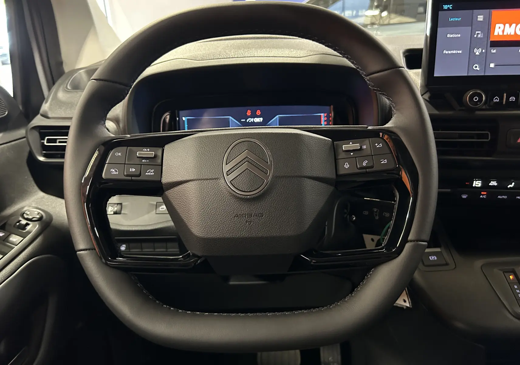 Vue rapprochée du volant noir du Citroën Berlingo Multispace 2026 avec commandes intégrées et tableau de bord digital.