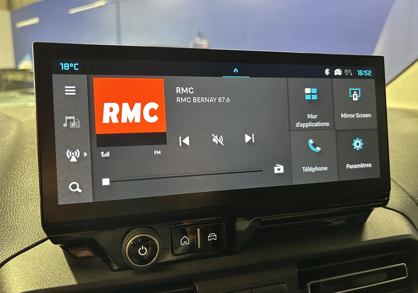 Écran tactile central du tableau de bord du Citroën Berlingo Multispace gris, affichant la radio RMC en intérieur.