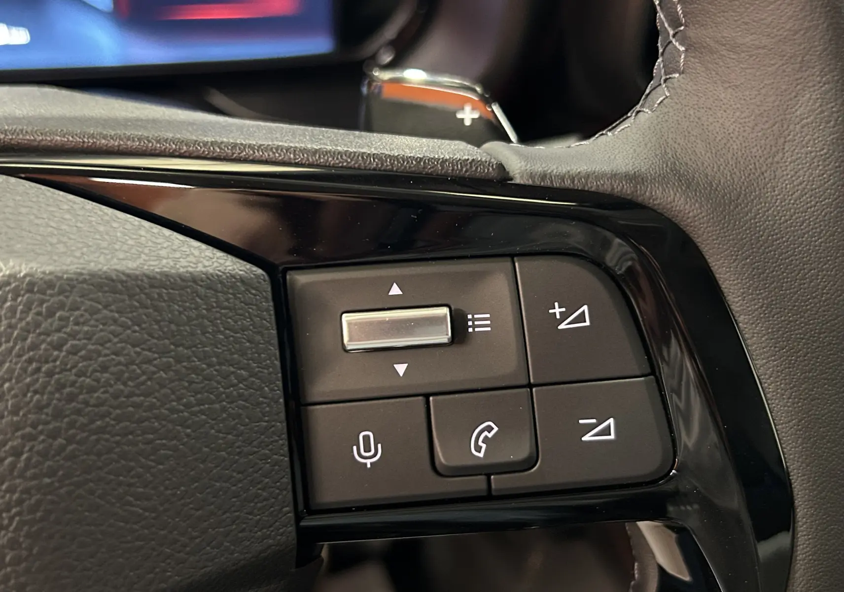 Gros plan sur les commandes multifonctions du volant cuir du Citroën Berlingo Multispace 2026, finition noire brillante.