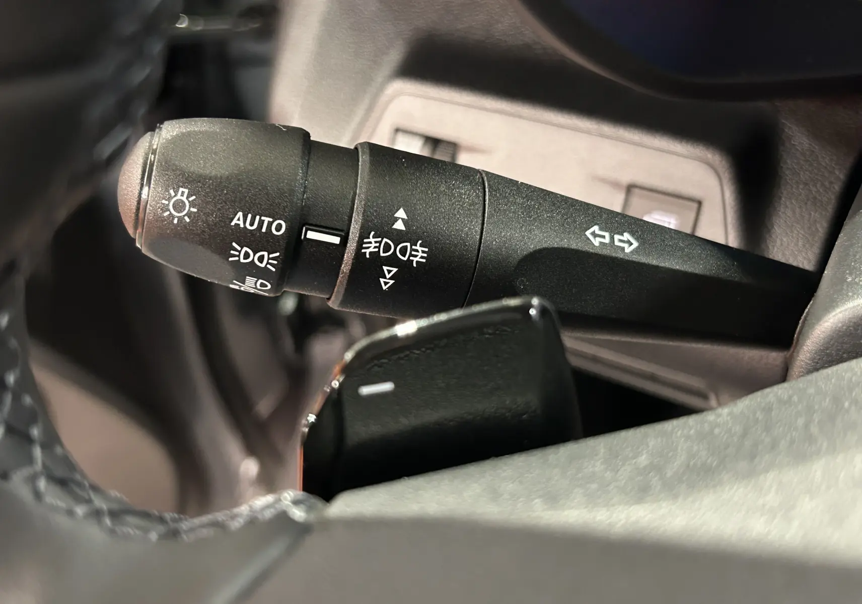 Gros plan sur la commande de phares et clignotants du Citroën Berlingo Multispace, intérieur noir.
