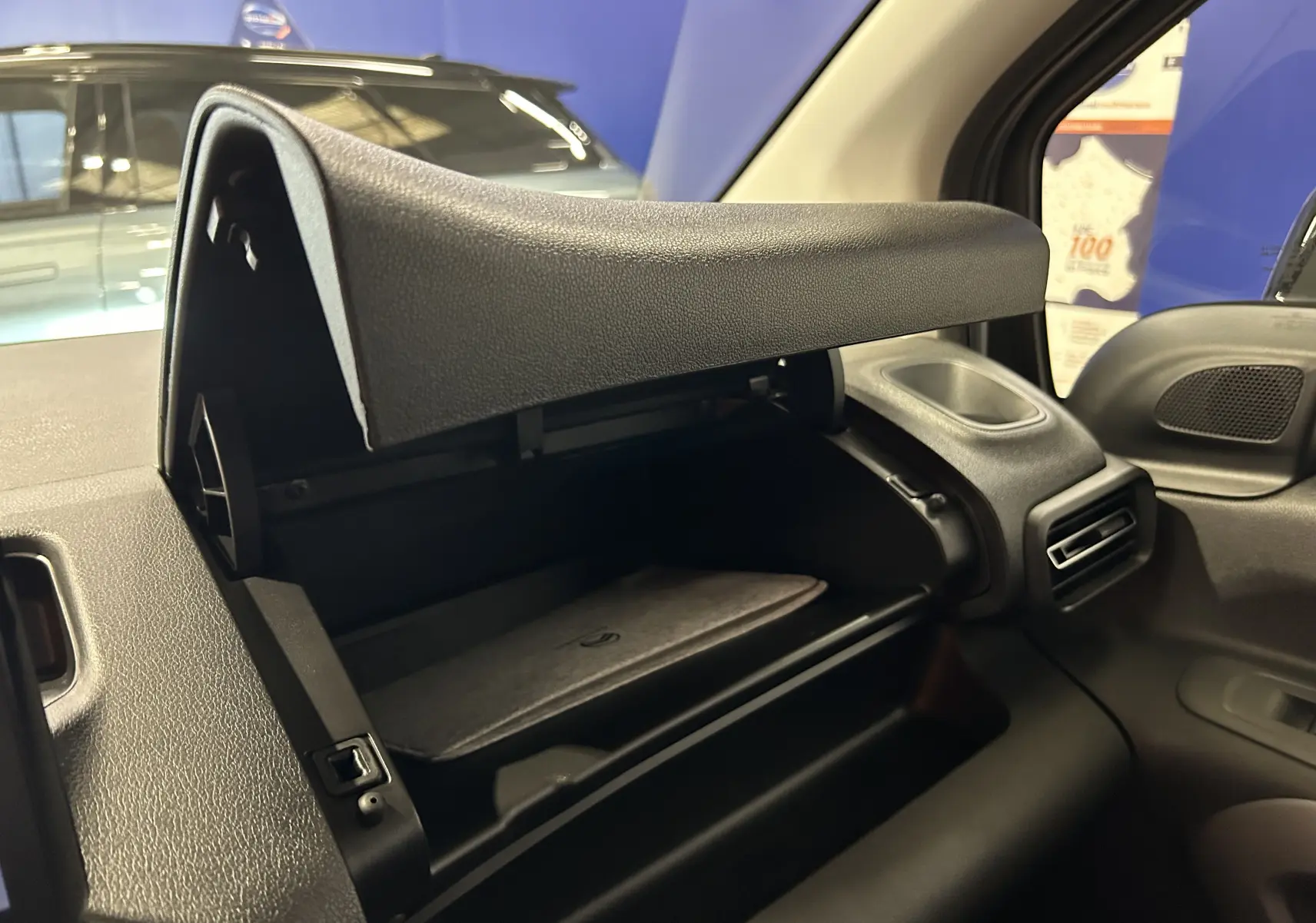 Gros plan sur la boîte à gants ouverte côté passager du Citroën Berlingo Multispace 2026, intérieur noir.