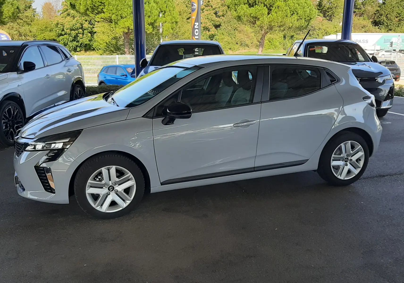 Renault Clio V gris Rafale vue de profil côté gauche, compacte avec jantes alliage et vitres teintées.
