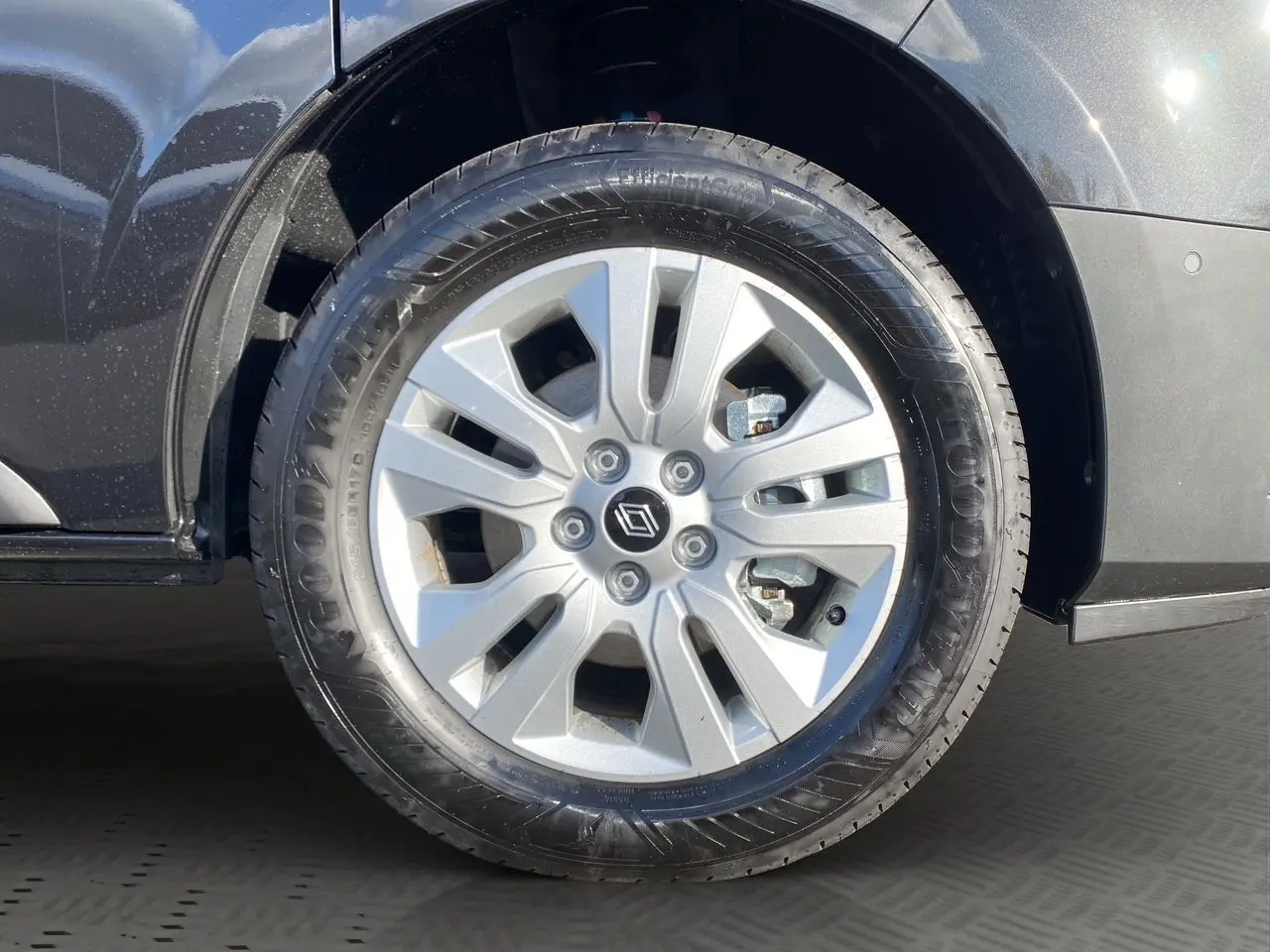 Gros plan sur la roue avant gauche du Renault Trafic Combi noir 2025 avec jante alliage 17 pouces et logo central Renault.