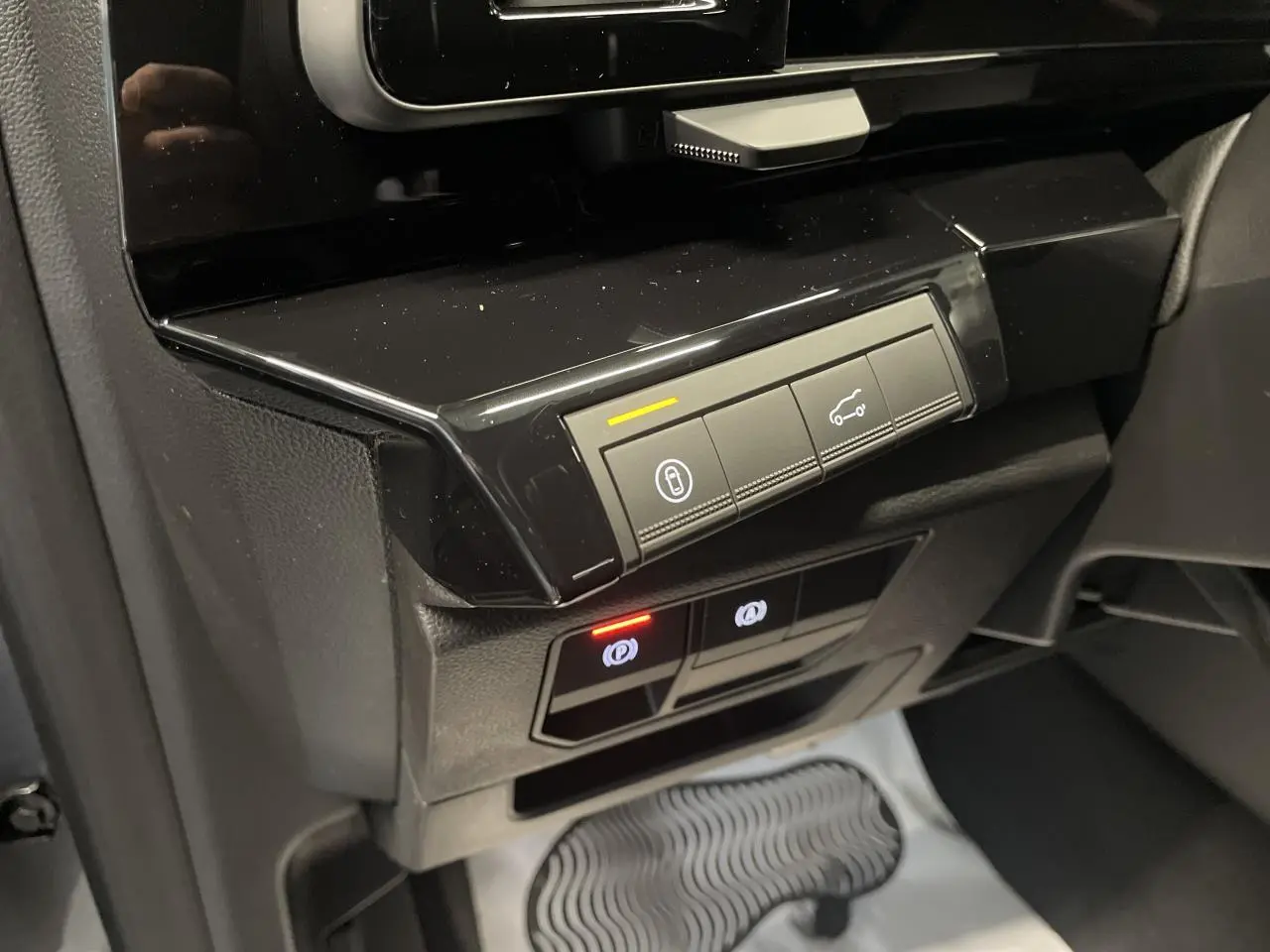 Vue rapprochée du tableau de bord noir brillant du Renault Austral Gris Schiste, avec commandes électroniques éclairées.