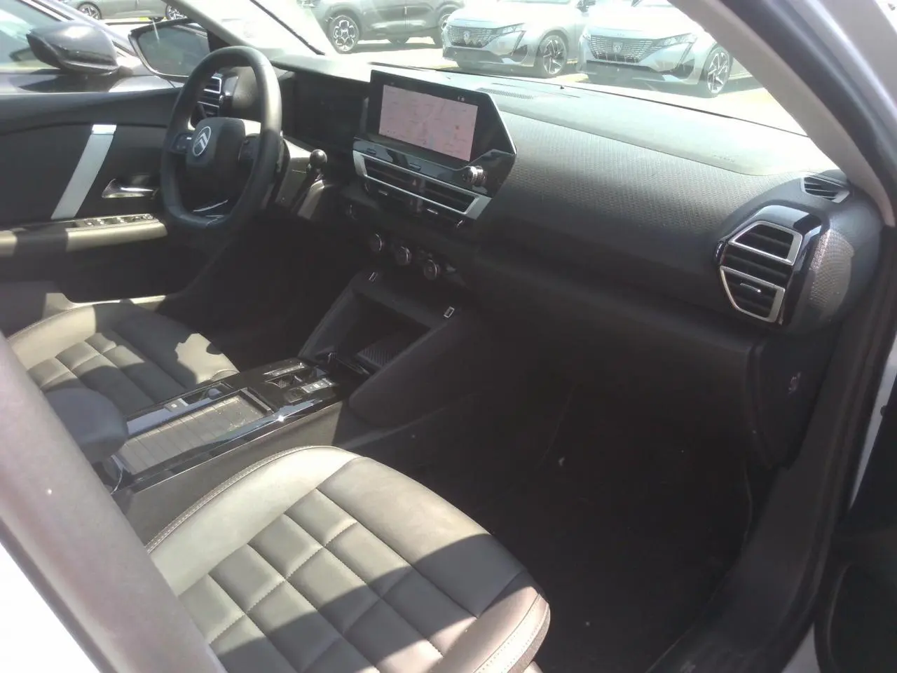 Intérieur avant droit de la Citroën C4 Hybrid blanc Okénite, avec tableau de bord numérique et écran tactile central.
