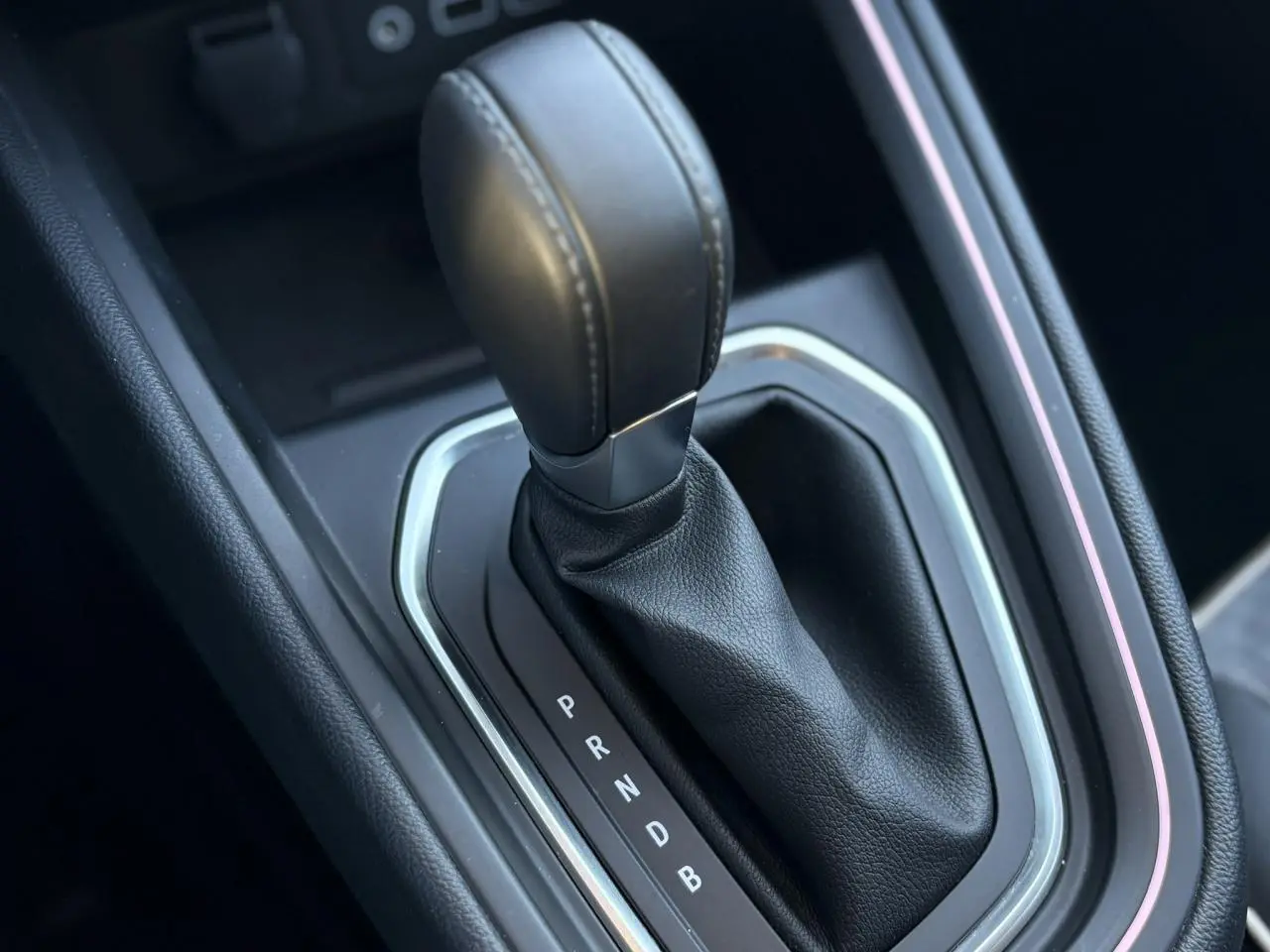 Gros plan sur le levier de vitesse automatique en cuir noir de la Renault Clio V E-Tech Full Hybrid 145 Techno.