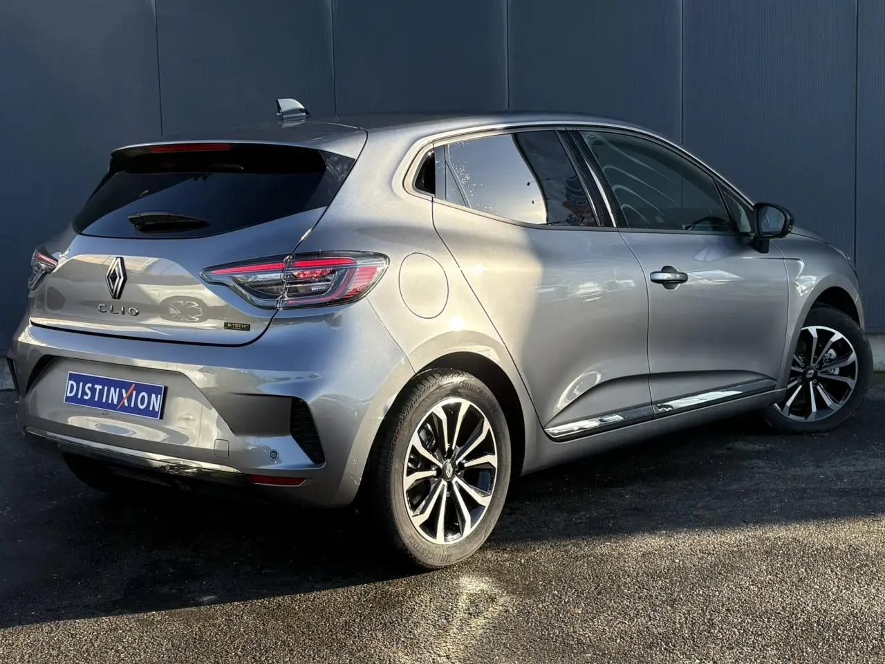 Vue 3/4 arrière droite d'une Renault Clio V E-Tech Full Hybrid 145 Techno gris schiste avec jantes alliage diamantées.