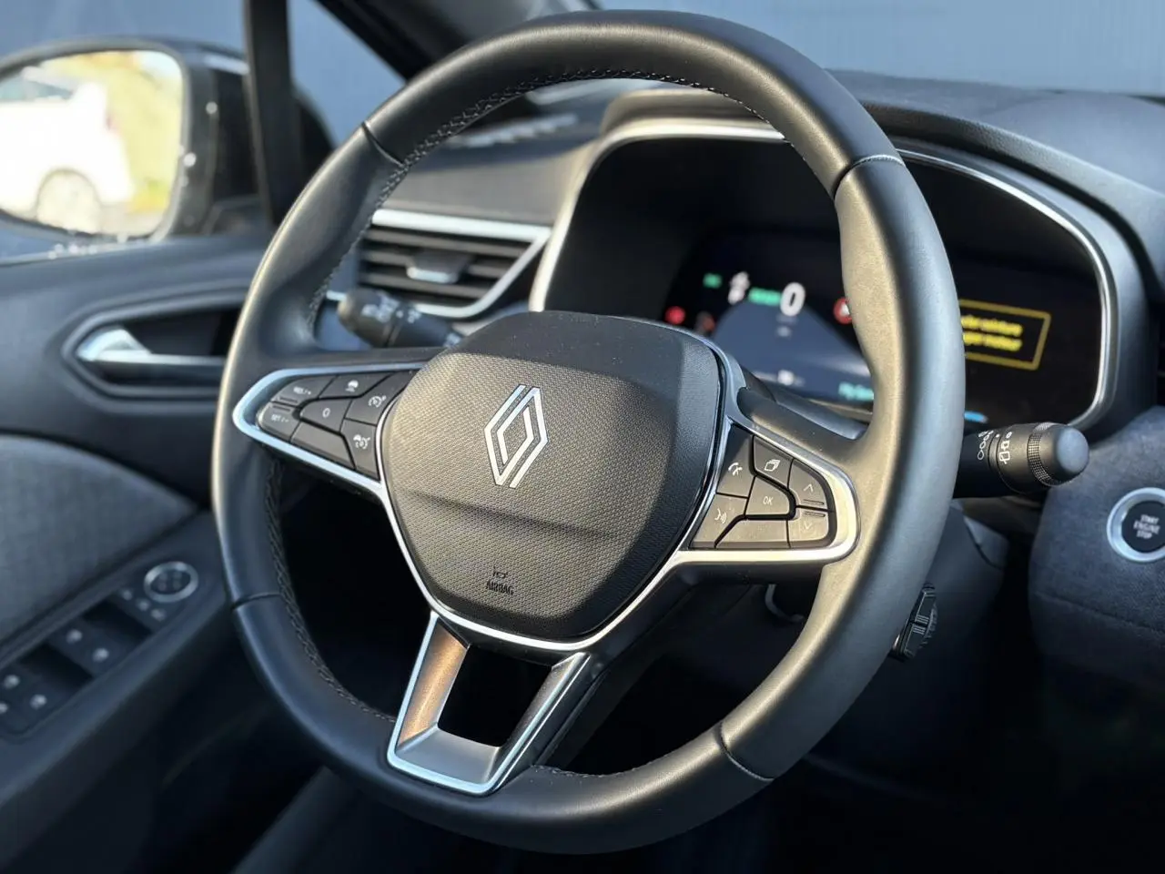 Vue rapprochée du volant noir de la Renault Clio V E-Tech 2025 avec commandes intégrées et tableau de bord numérique.