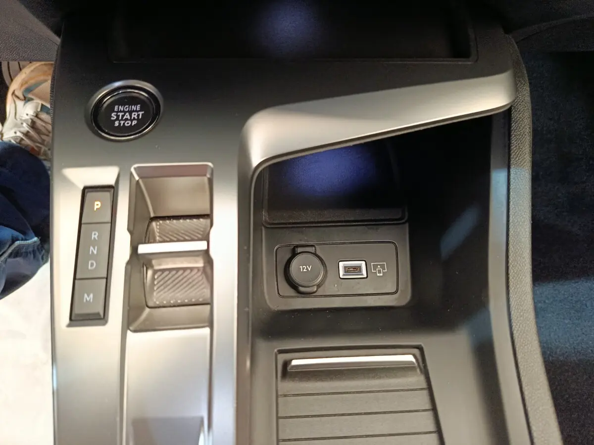 Gros plan sur la console centrale de la Peugeot 308 blanche, avec bouton start, levier de boîte auto et prise 12V/USB.