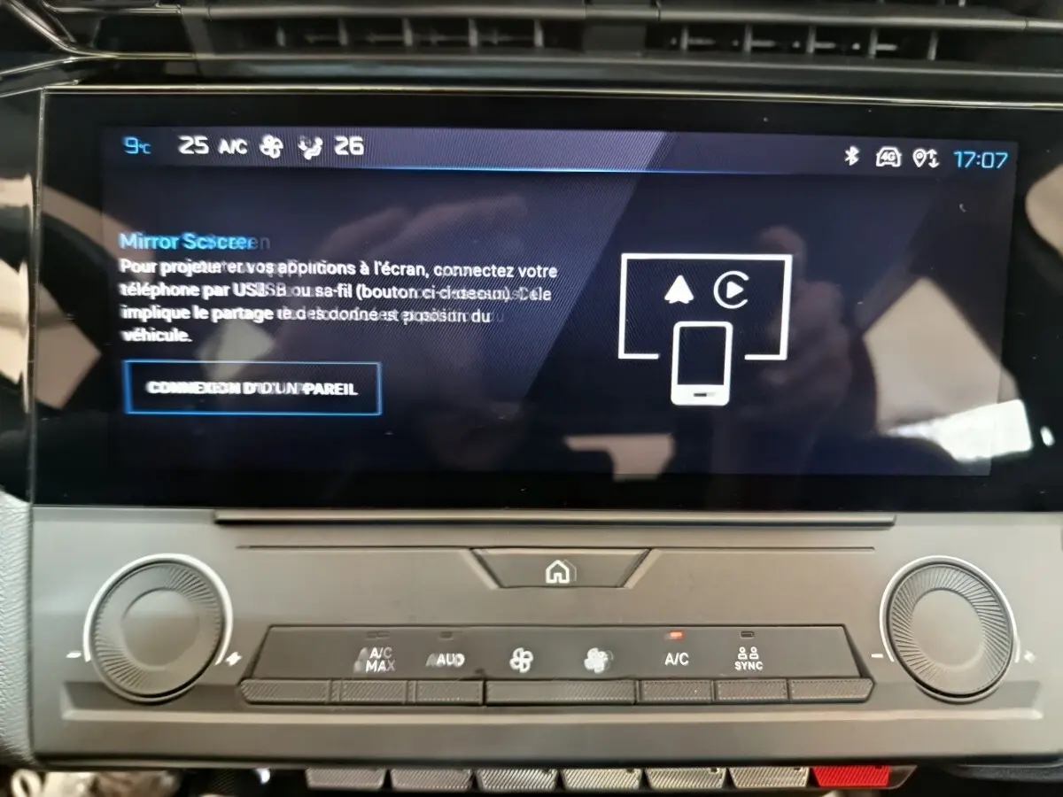 Vue rapprochée de l’écran tactile central et des commandes de climatisation d’une Peugeot 308 blanche de 2022.