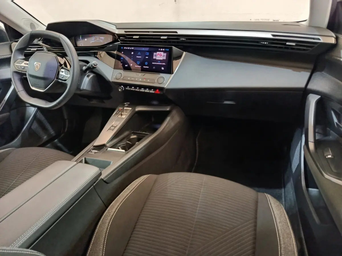 Vue intérieure avant droite de la Peugeot 308 2022 avec tableau de bord digital et volant cuir multifonctions.