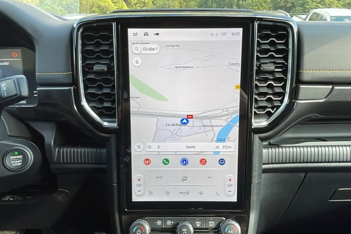 Vue intérieure centrée sur l’écran tactile vertical du Ford Ranger Wildtrak 2025 avec tableau de bord noir et finitions jaunes.