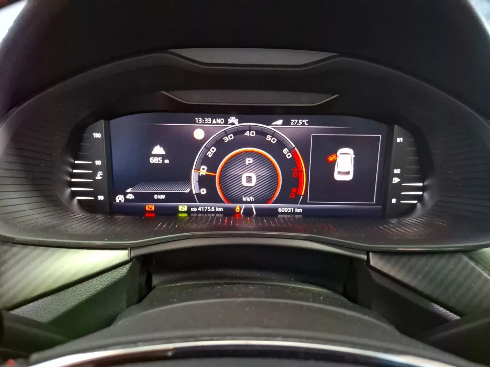 Vue rapprochée du tableau de bord numérique du Skoda Kamiq blanc, affichant la vitesse à 0 km/h et divers indicateurs.