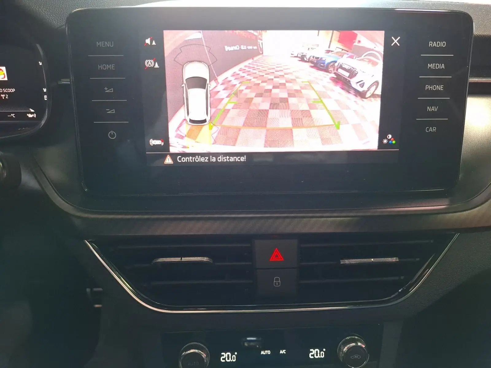 Écran central du Skoda Kamiq blanc 2021 montrant la caméra de recul avec alertes de distance, vue intérieure.