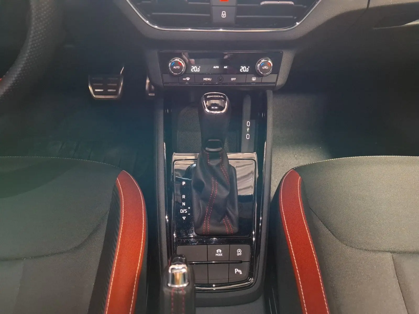 Vue rapprochée de la console centrale du Skoda Kamiq blanc 2021, avec levier de boîte auto et surpiqûres rouges.