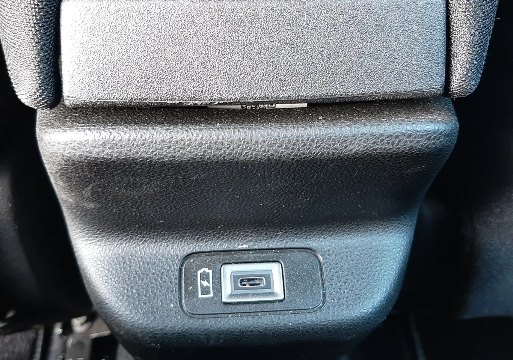 Prise USB de recharge située à l'arrière de la console centrale, intérieur noir du FIAT 600 Vert Sky 2025.