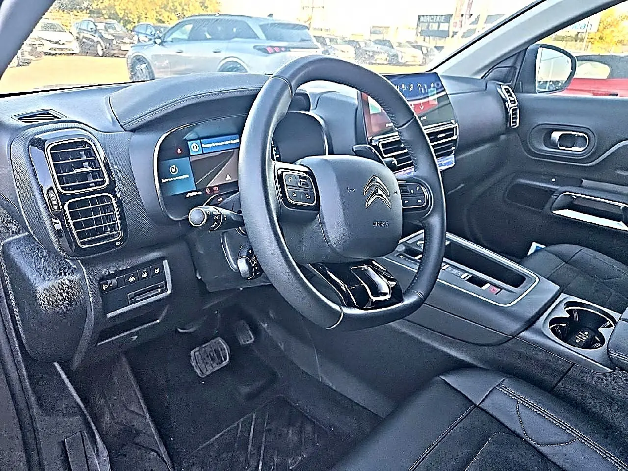 Intérieur du Citroën C5 Aircross 2024, vue côté conducteur, volant cuir multifonction et tableau de bord digital.
