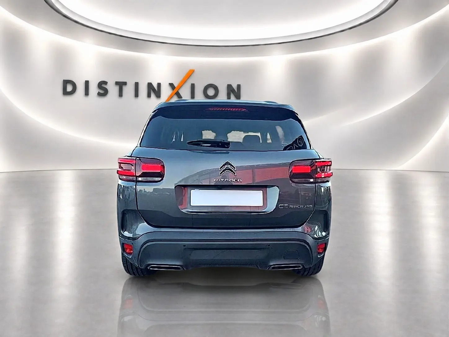 Vue arrière du Citroën C5 Aircross gris platinium 2024 dans un showroom avec éclairage moderne et logo Distinxion.