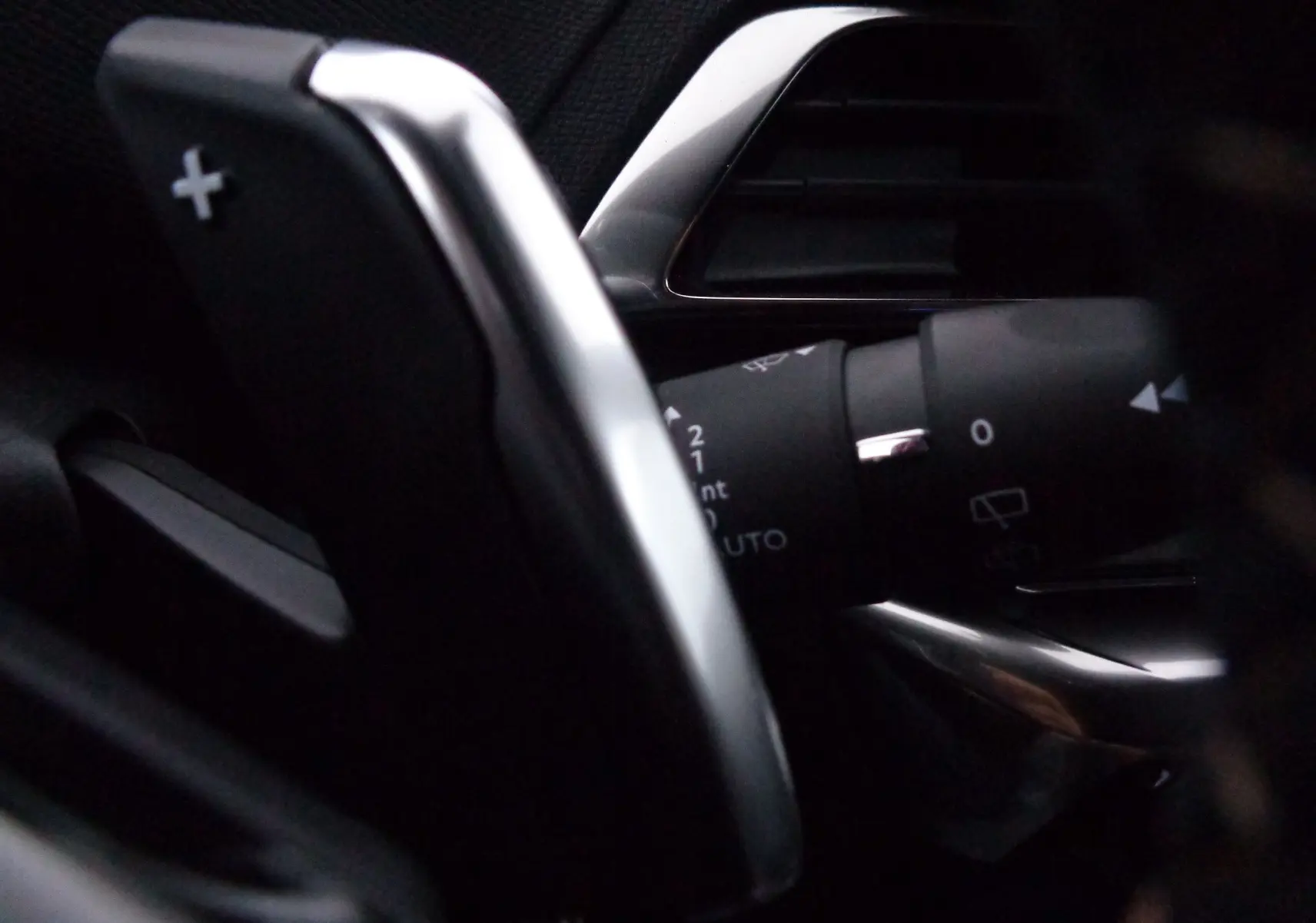 Gros plan sur la palette de changement de vitesse + côté gauche du Peugeot 3008 gris Artense, intérieur sombre.