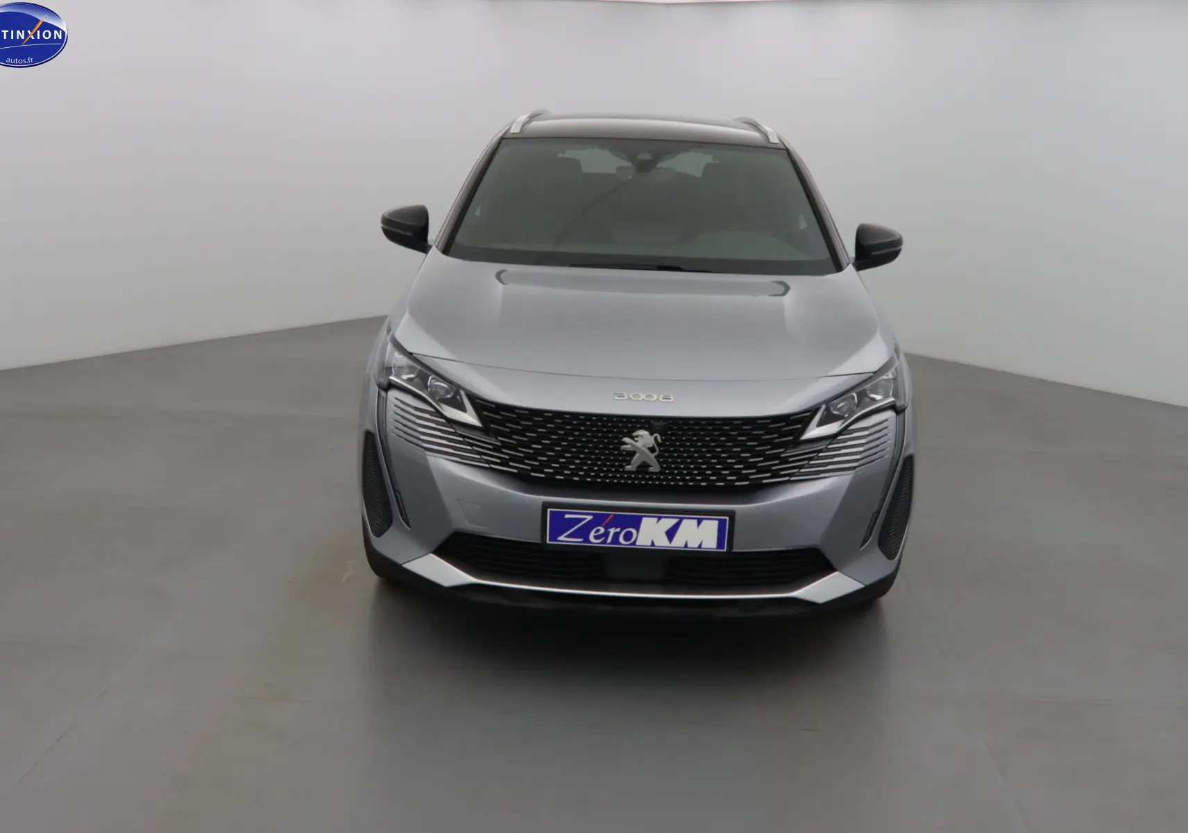 Vue frontale d'un Peugeot 3008 gris Artense métallisé avec calandre noire et logo lion central.