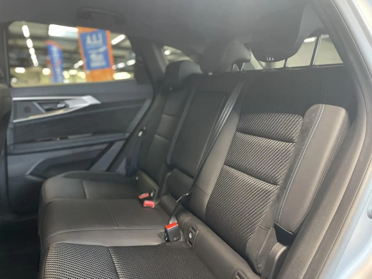 Banquette arrière en tissu carbone et Alcantara noir avec surpiqûres tricolores dans un Renault Austral 2025.