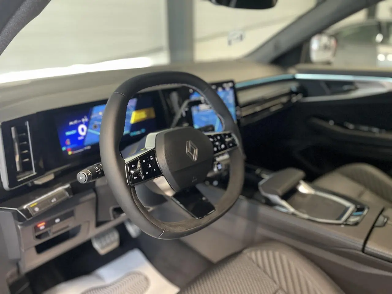Intérieur du Renault Austral 2025 vu côté conducteur, volant Alcantara et tableau de bord numérique lumineux.