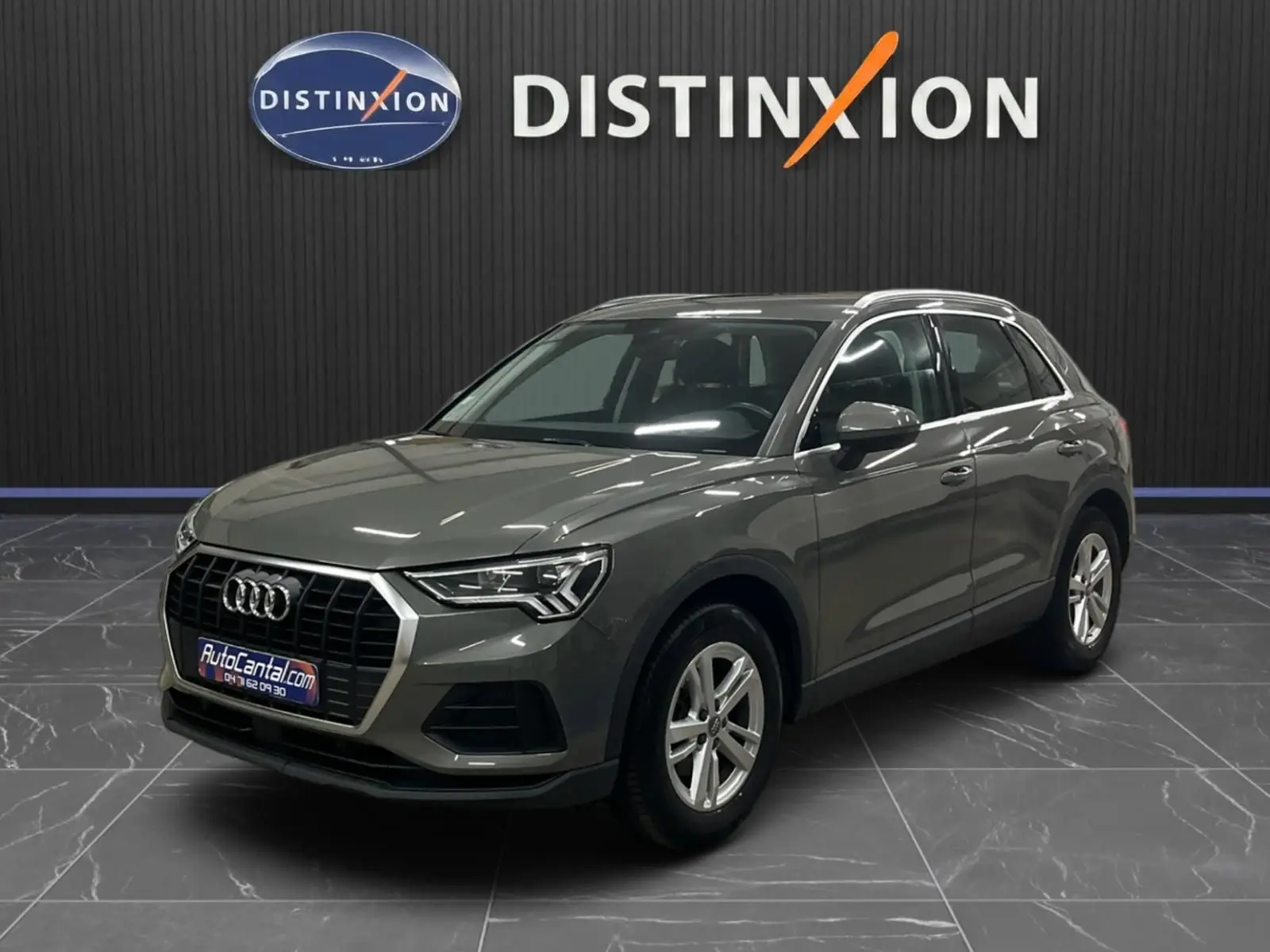 Audi Q3 Business gris vue 3/4 avant droit, avec calandre hexagonale et jantes alliage cinq branches.
