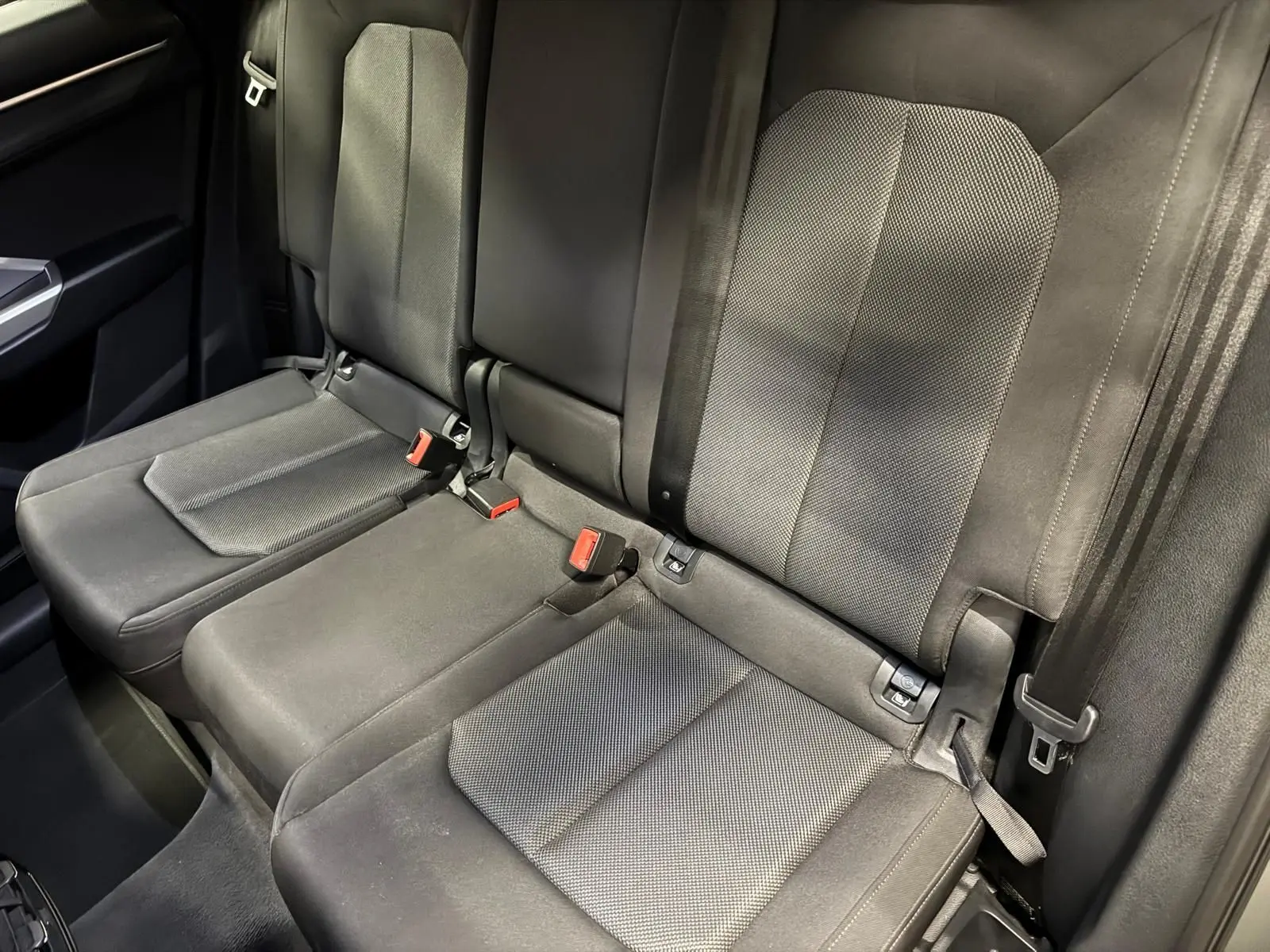 Vue rapprochée des sièges arrière en tissu gris du SUV Audi Q3 Business, avec fixations Isofix visibles.