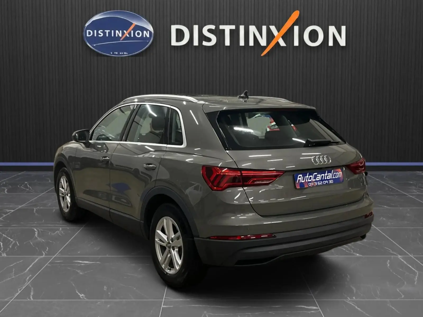 Audi Q3 Business gris vu en 3/4 arrière droit, avec feux arrière LED dynamiques et jantes alliage argentées.