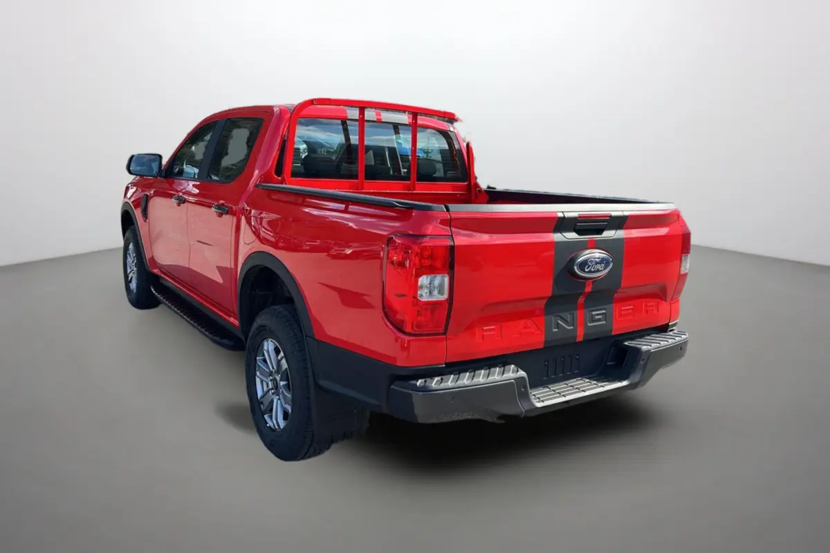 Ford Ranger rouge racing vu en 3/4 arrière droit avec bande noire et jantes alu 17 pouces tout-terrain.