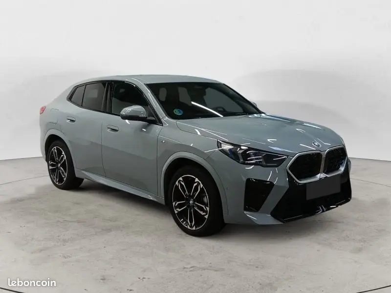 BMW X2 2025 gris Skyscraper en vue 3/4 avant, mettant en valeur sa calandre noire et ses phares LED distinctifs.