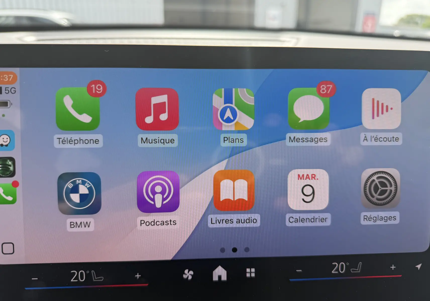 Écran tactile intérieur de BMW X2 2025 affichant les applications Apple CarPlay avec commandes climatisation visibles en bas.