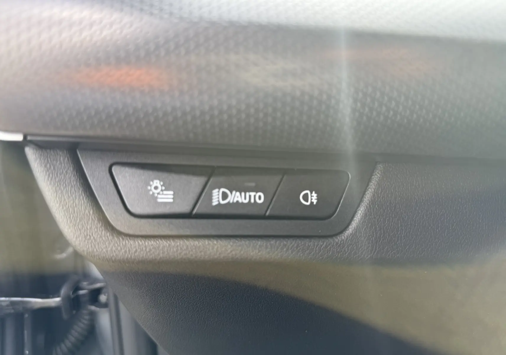 Gros plan sur les boutons de commande des phares automatiques et antibrouillard dans une BMW X2 Skyscraper 2025.