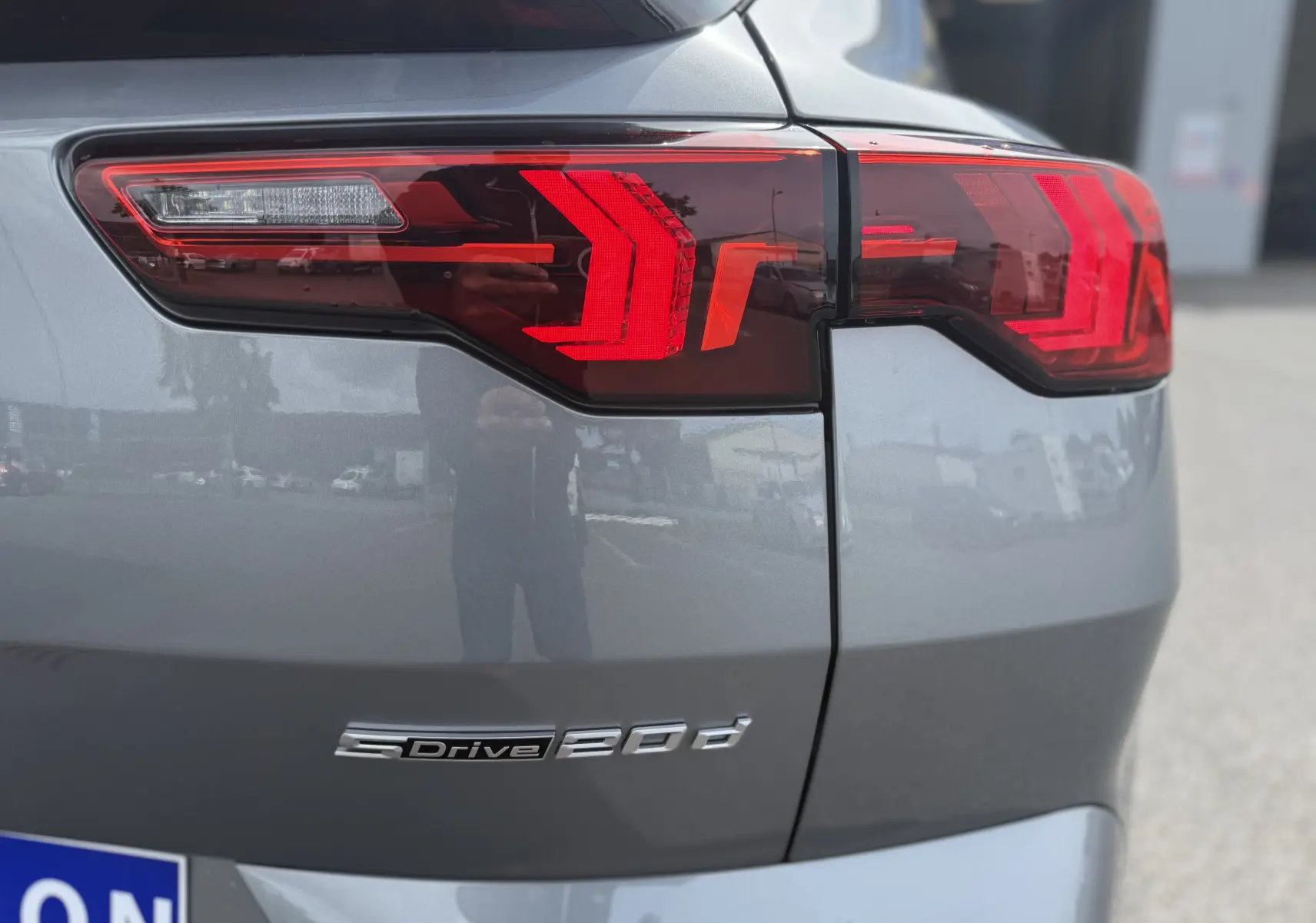 Gros plan sur le feu arrière droit rouge et la partie arrière grise métallisée du BMW X2 2.0DA 163 CH M SPORT 2025.