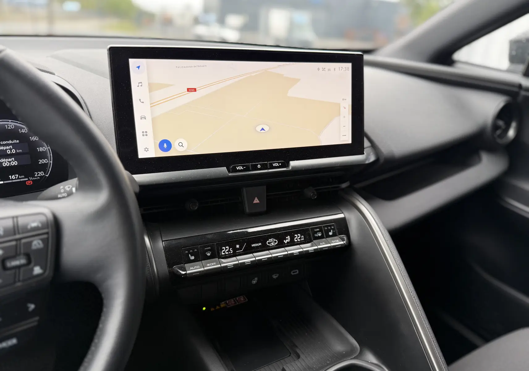 Vue intérieure du tableau de bord du Toyota C-HR Hybride 2024, écran tactile central avec navigation et commandes climatisation digitales.
