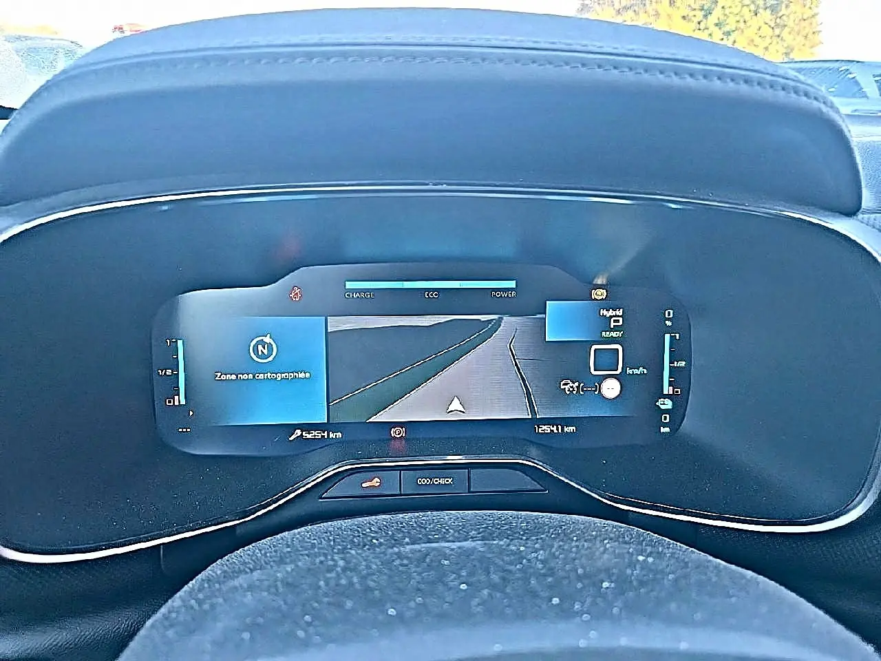 Vue rapprochée du tableau de bord numérique du Citroën C5 Aircross hybride 2024 affichant la navigation et les indicateurs de charge.