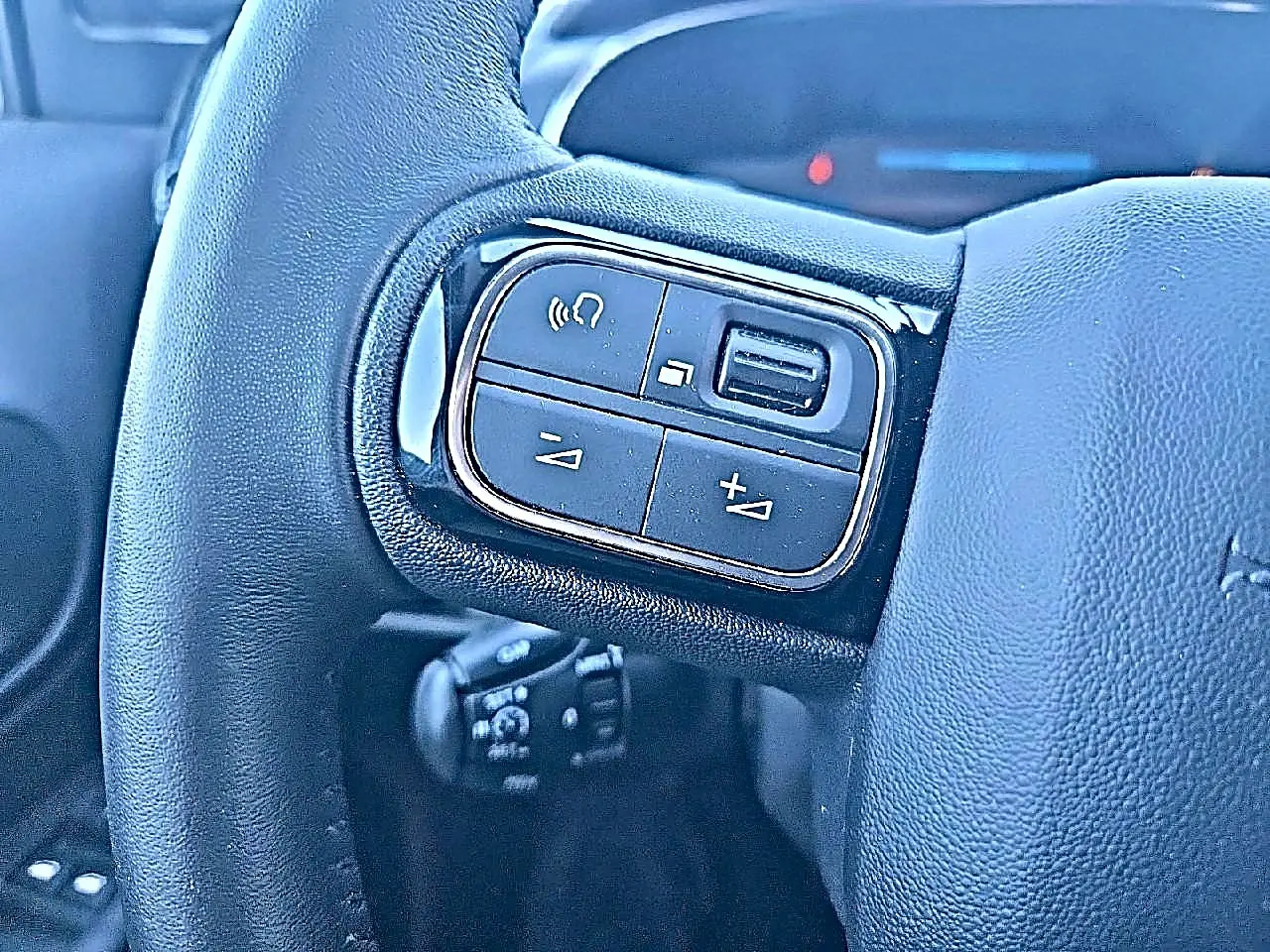 Gros plan sur les commandes gauche du volant cuir noir du Citroën C5 Aircross 2024 hybride rechargeable.