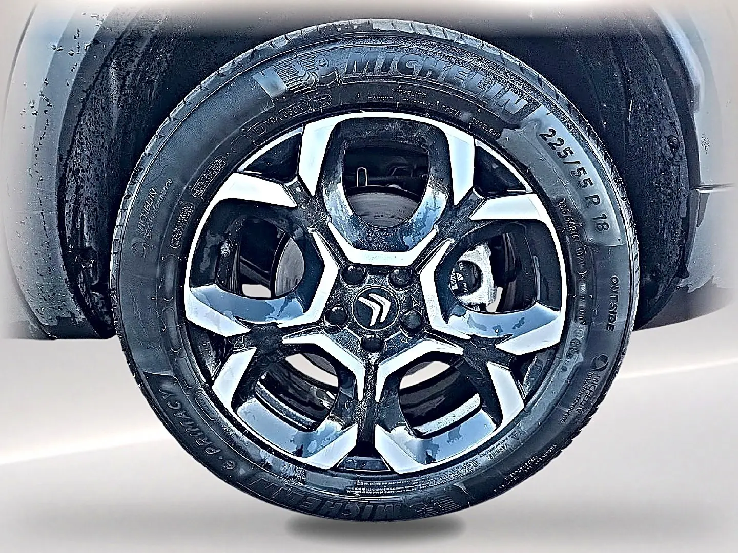 Gros plan sur la jante alu noire et argentée de 18 pouces avec logo Citroën au centre, montée sur pneu Michelin.