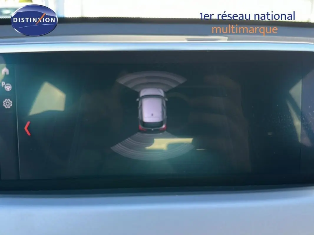 Affichage écran intérieur montrant la vue aérienne du BMW X1 gris foncé avec capteurs de proximité actifs.