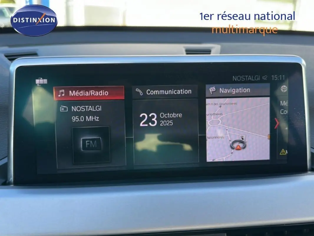 Écran central de la BMW X1 F48 LCI 2022 affichant radio, communication et navigation, intérieur gris clair.