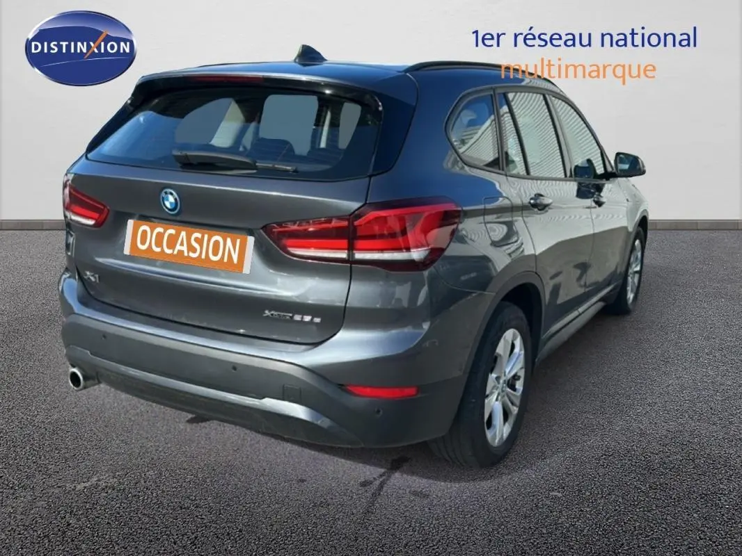BMW X1 gris foncé vue 3/4 arrière droit, avec jantes alliage 18 pouces et feux arrière LED distinctifs.