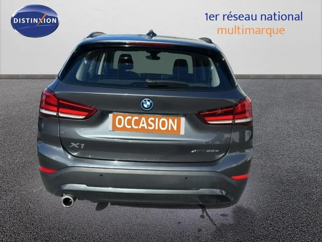 Vue arrière d’un BMW X1 gris foncé avec feux rouges et plaque d’immatriculation orange « OCCASION ».